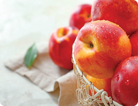 Sweet ripe nectarines in basket on table