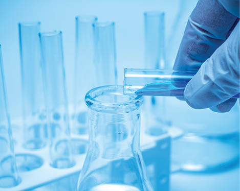 A researcher's hand holding a test tube containing blue liquid; Shutterstock ID 1720007947; Purchase Order: RYL
