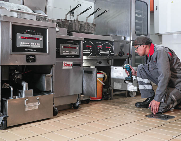 Rentokil technician inspecting for activity in restaurant / QSR