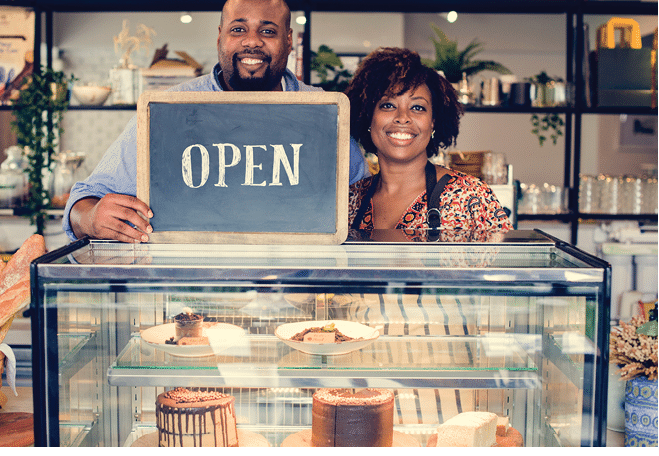 Cake cafe owners with open sign