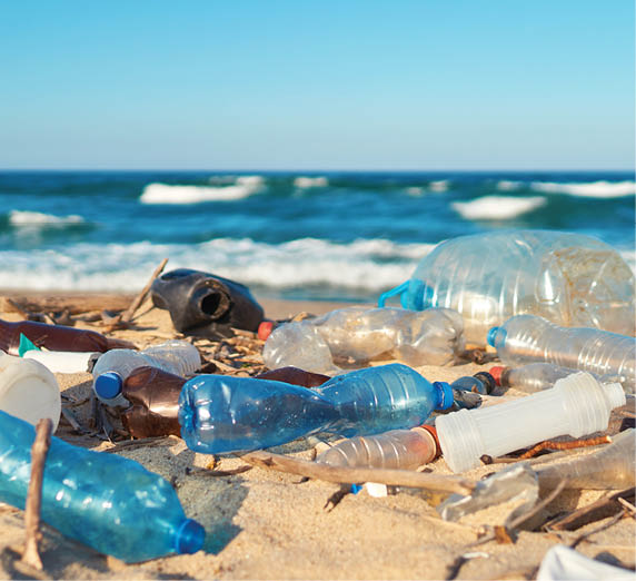 Spilled garbage on the beach of the big city. Empty used dirty plastic bottles. Dirty sea sandy shore the Black Sea. Environmental pollution. Ecological problem. Moving waves in the background