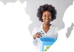 A woman collecting and separating recyclable garbage plastic bottles into a trash bin at home. African american woman holding recycling plastic bottles smiling with a happy and cool smile on face. 