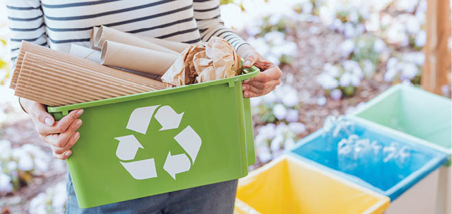 Activist taking care of environment, sorting paper waste to proper recycling bin on terrace