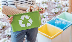 Activist taking care of environment, sorting paper waste to proper recycling bin on terrace