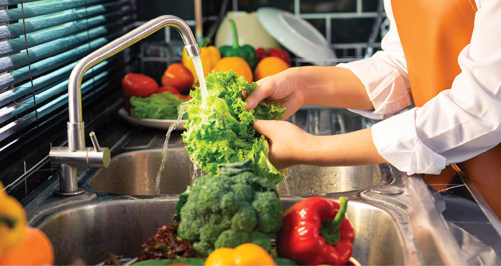 Woman hands washing Vegetables for Preparation of vegan salad on the worktop near to sink in a modern kitchen, Homemade healthy food concept